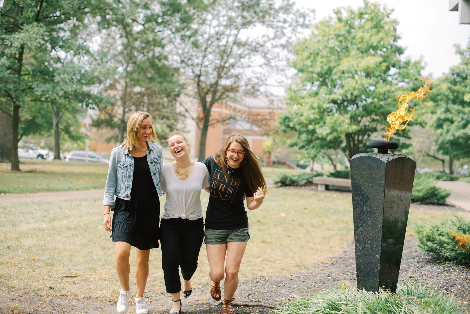 female students chatting on a bench outside college building