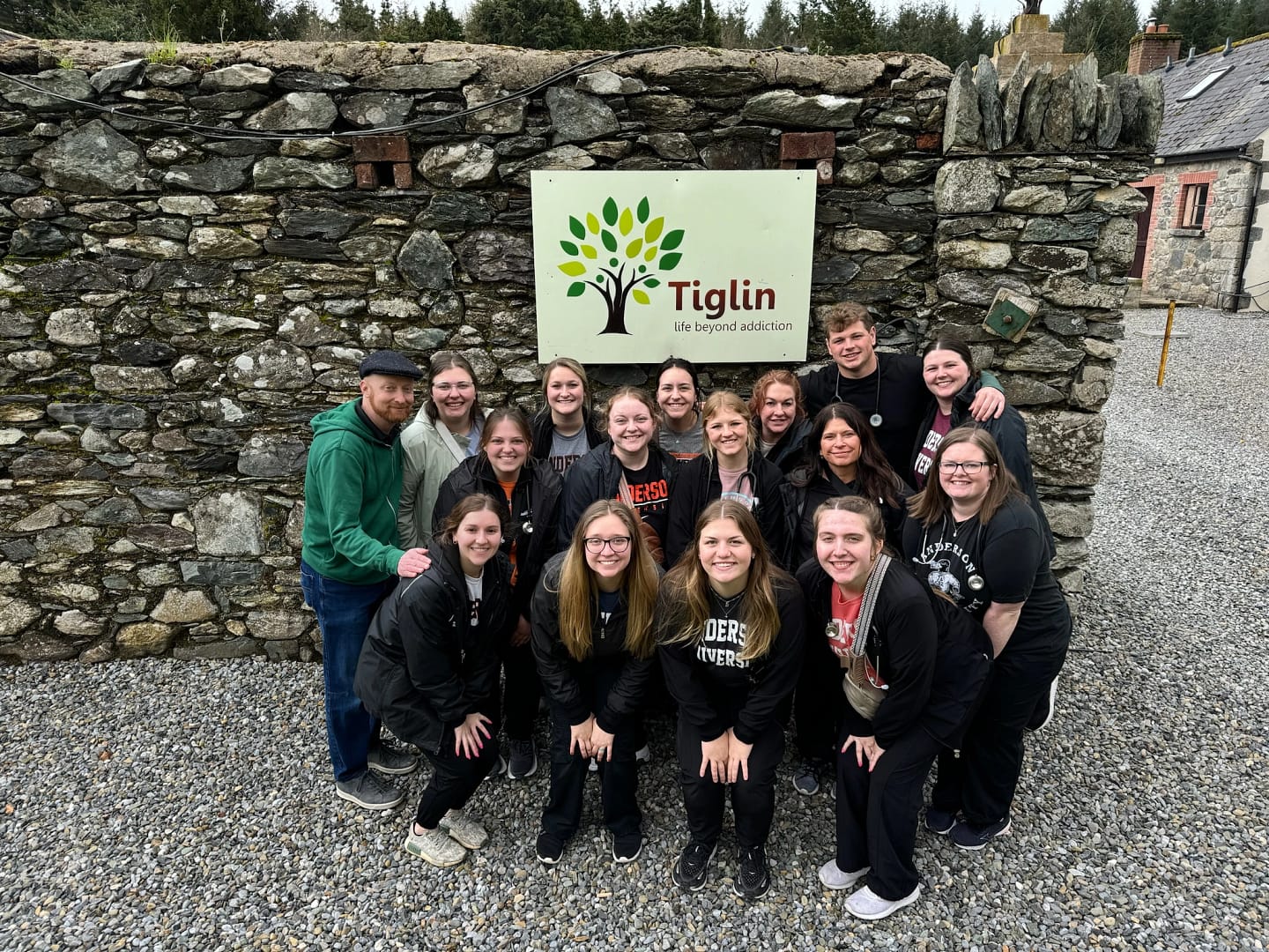 Nursing students pose together in front of a sign in Ireland