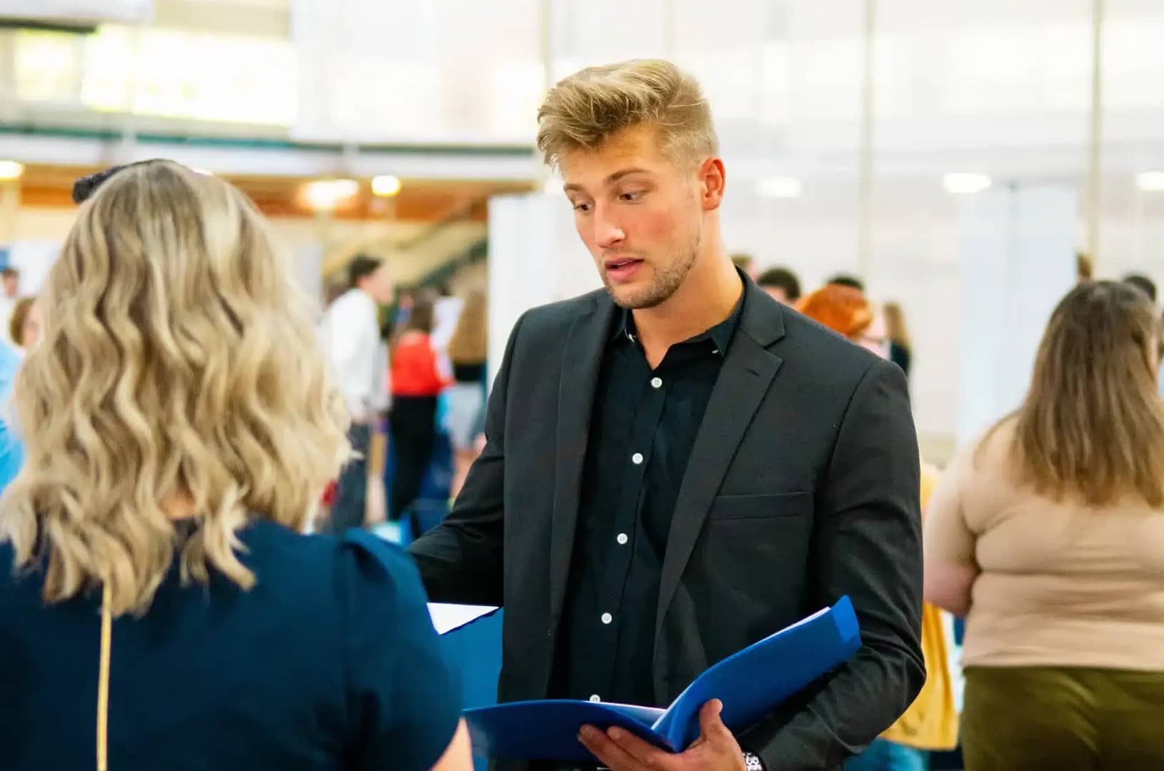 student handing resume to recruiter