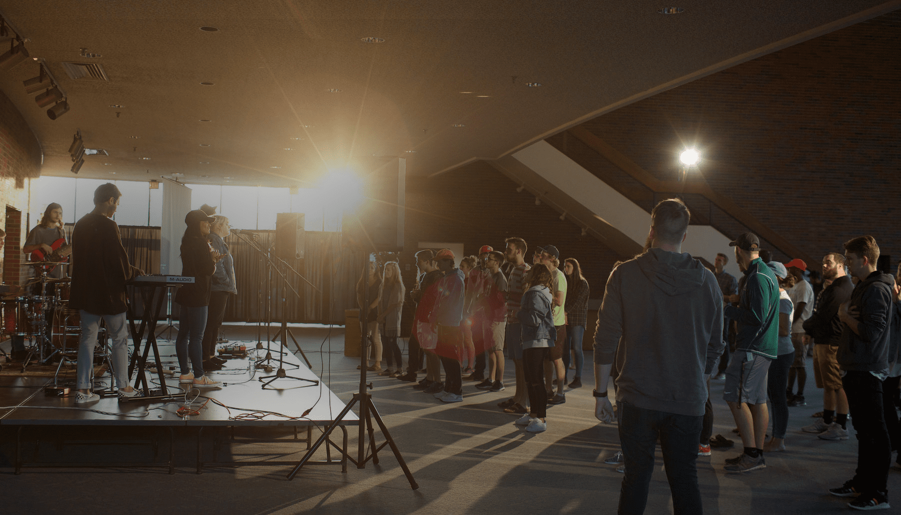 worship leaders on stage with students standing and singing