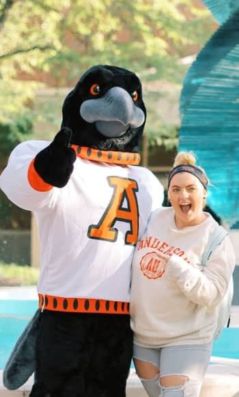 President Pistole and student walking at Anderson University Indiana