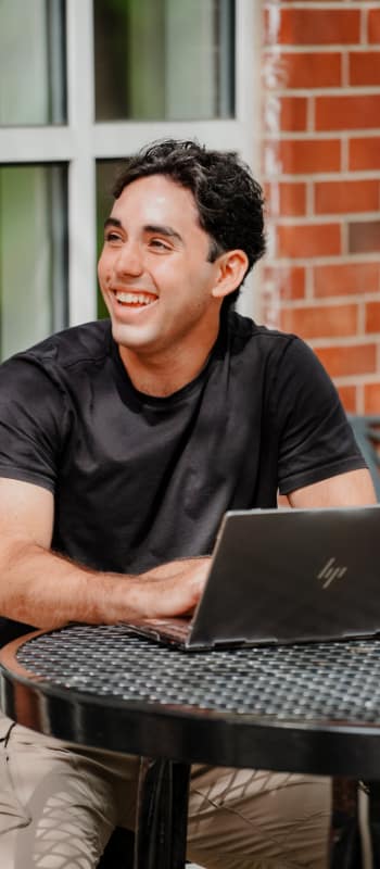 A student sitting at an outside table