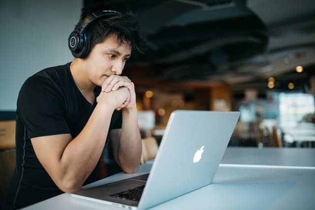 Student wearing headphones and working on a laptop computer