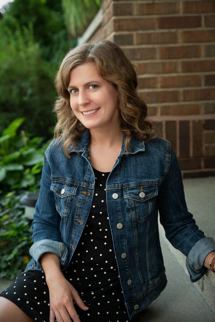 kayla is seated, smiling  into the camera