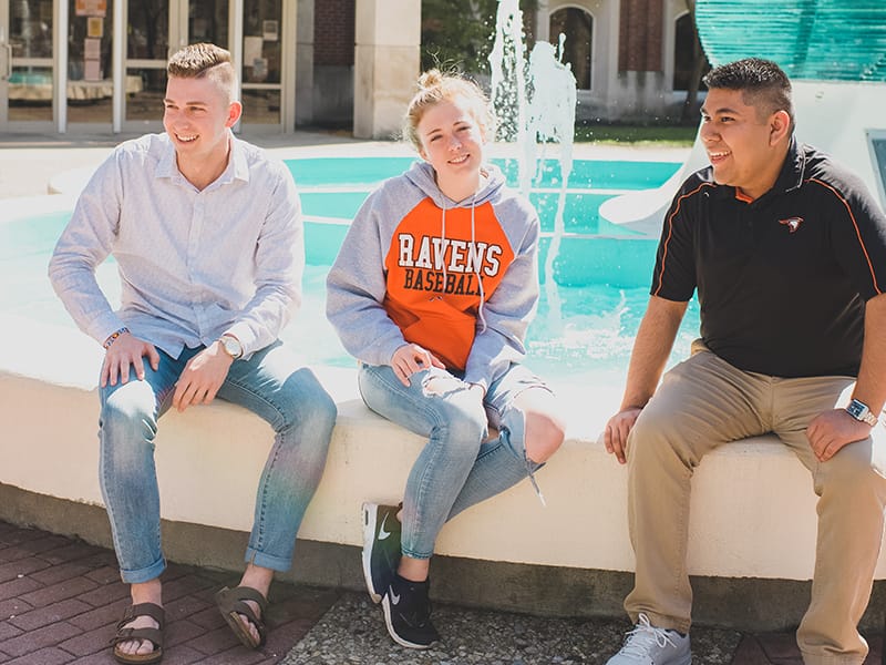 Photo of Tarah sitting with two boys in front of the Helios fountain