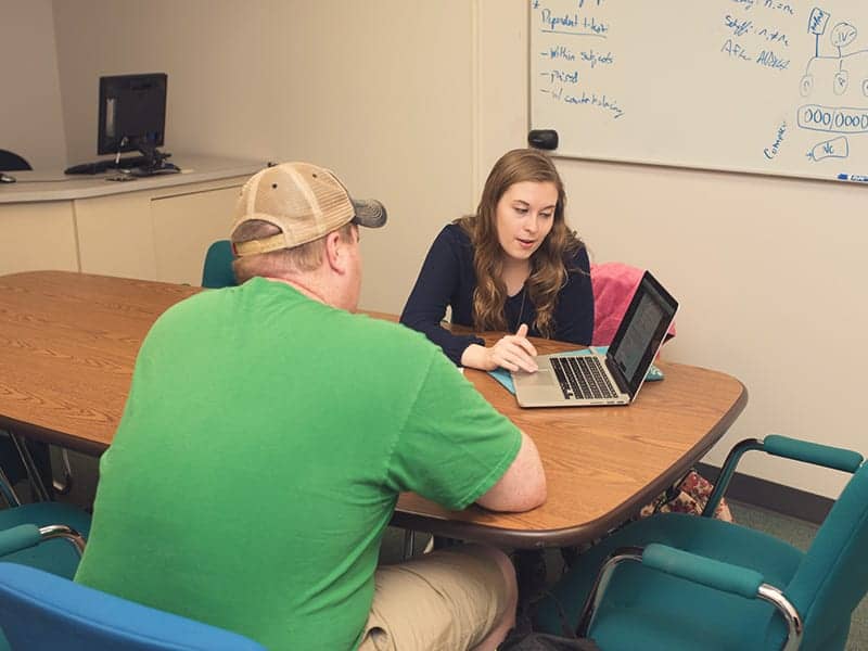 Students doing classwork together on one computer.